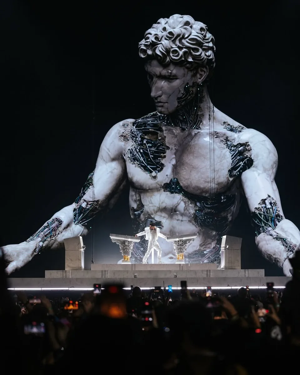 Escenario de ÆDEN con una estatua gigante en pantalla