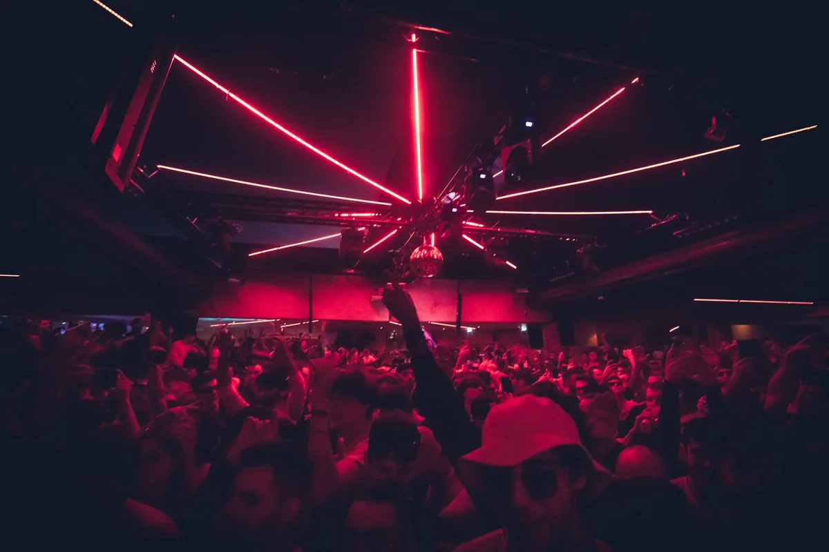 Pista llena bajo luces rojas en una sesión de ANOTR