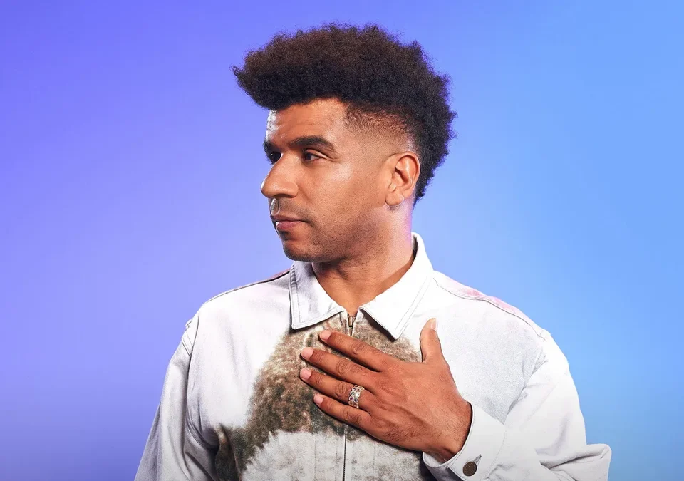Jamie Jones, fundador de Paradise, con la mano en el pecho sobre fondo azul