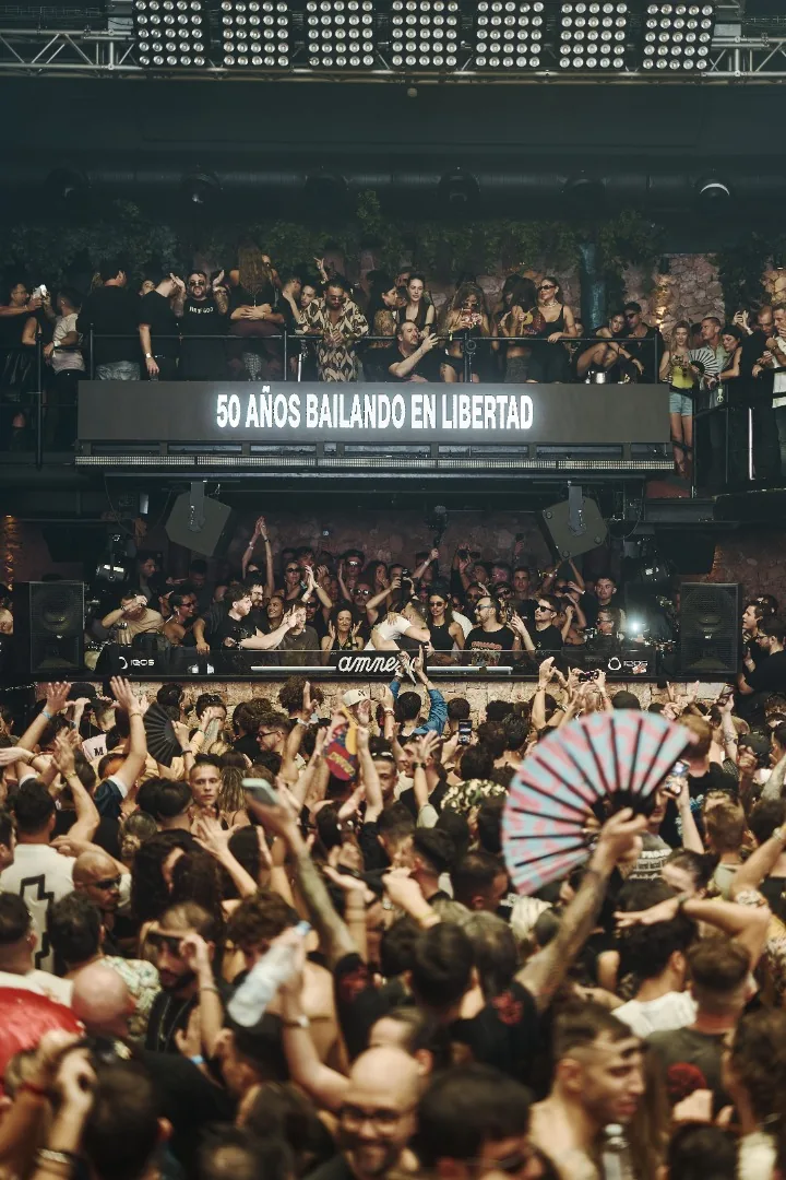 Pista de Amnesia llena bajo la pantalla con el lema 50 años bailando en libertad